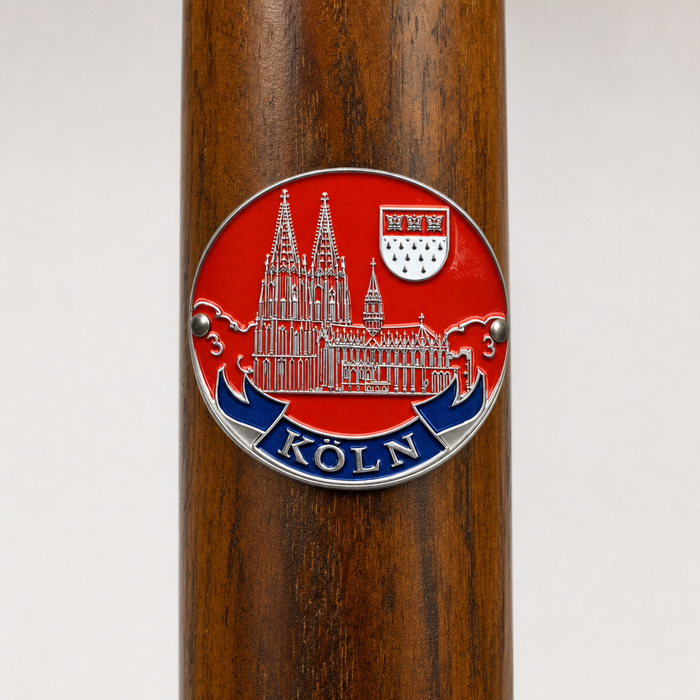Koln hiking stick medallion installed on a wooden hiking staff