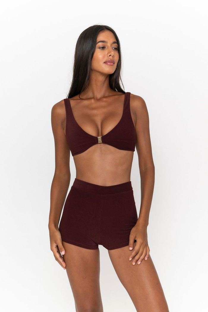 Woman wearing a Burgundy Terrycloth Bralette Top and Micro Terry High Waist Shorts as set on a white background